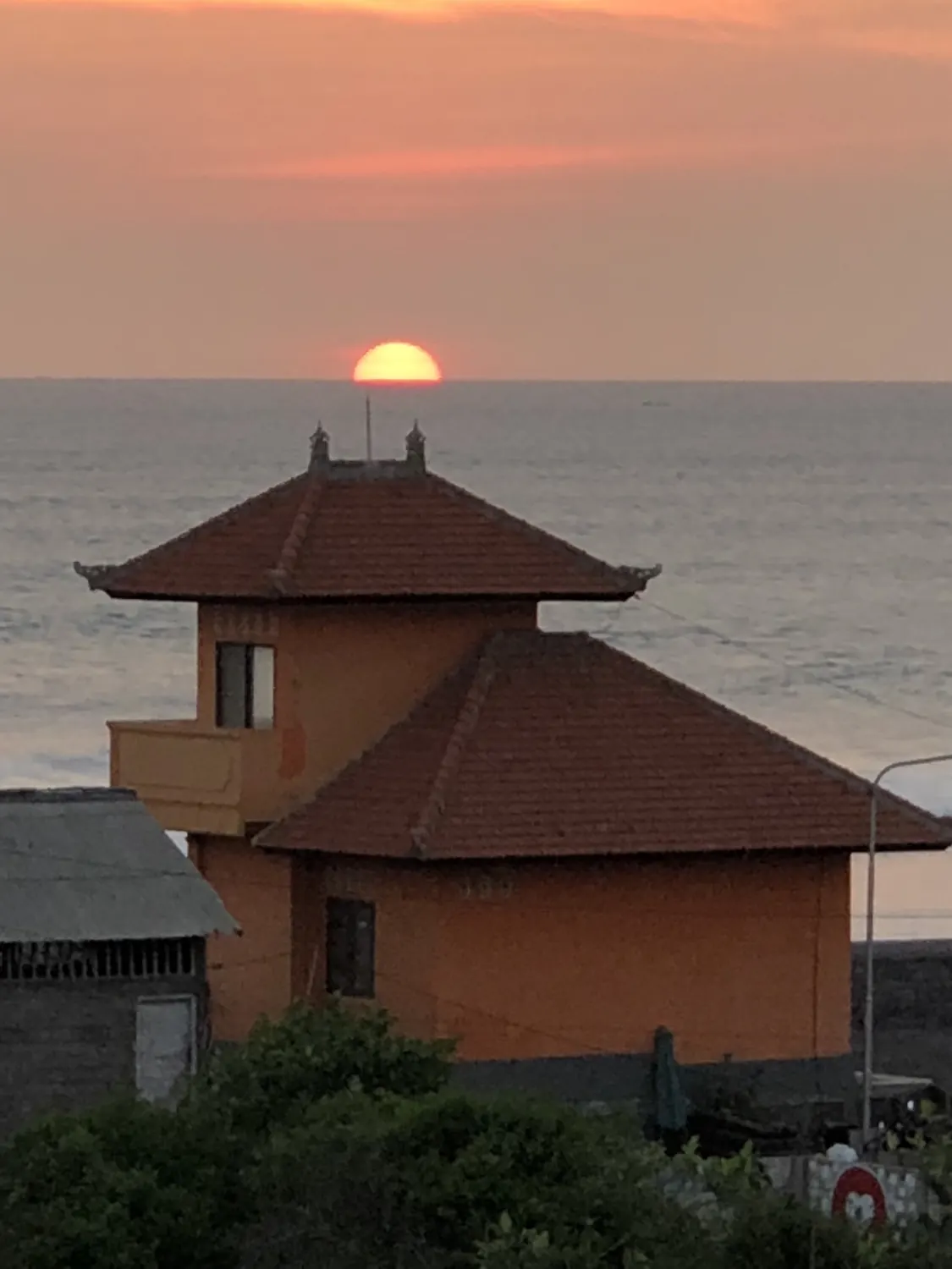 The sun behind the orange tower