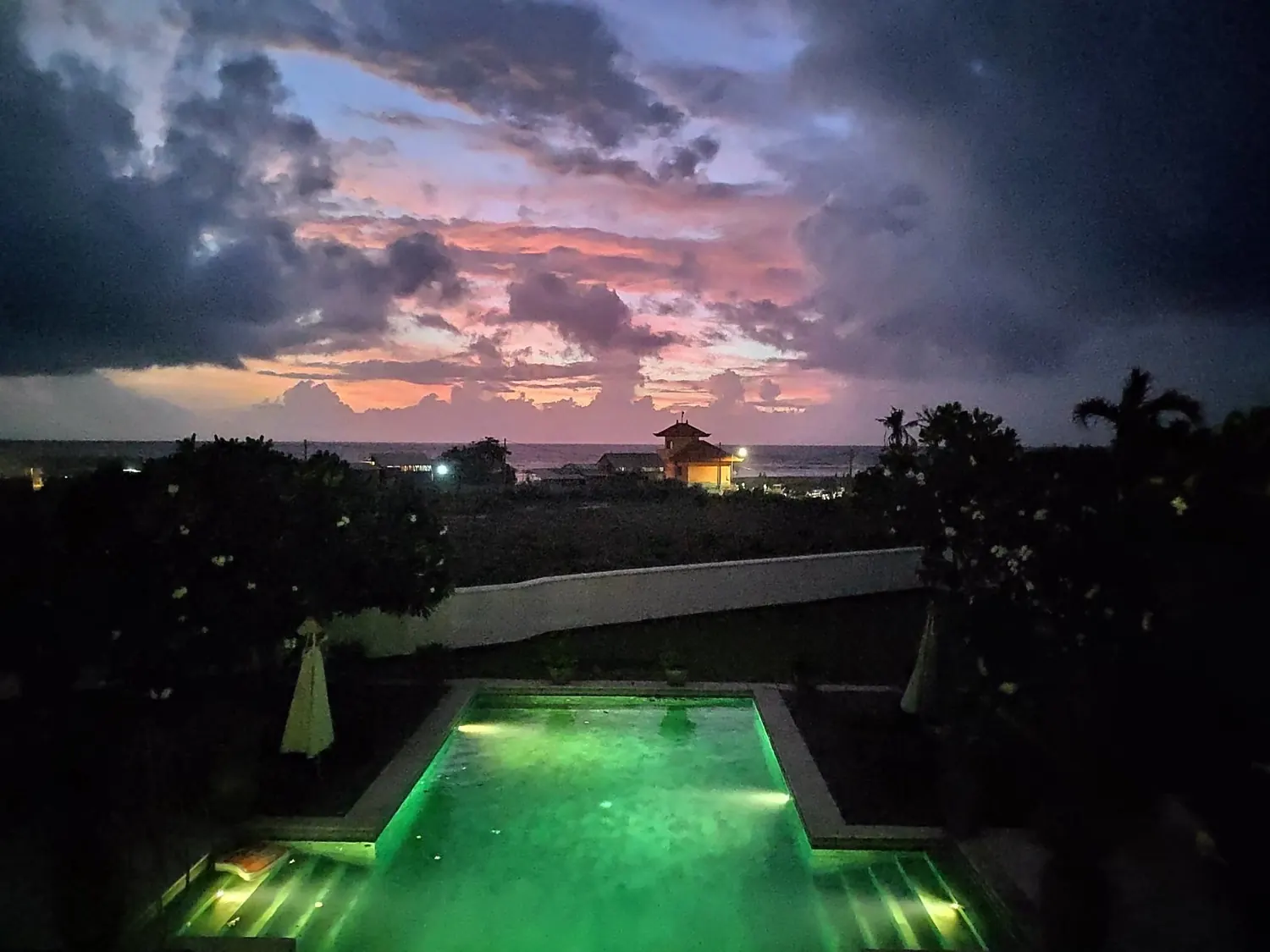 The green-lit pool at dusk
